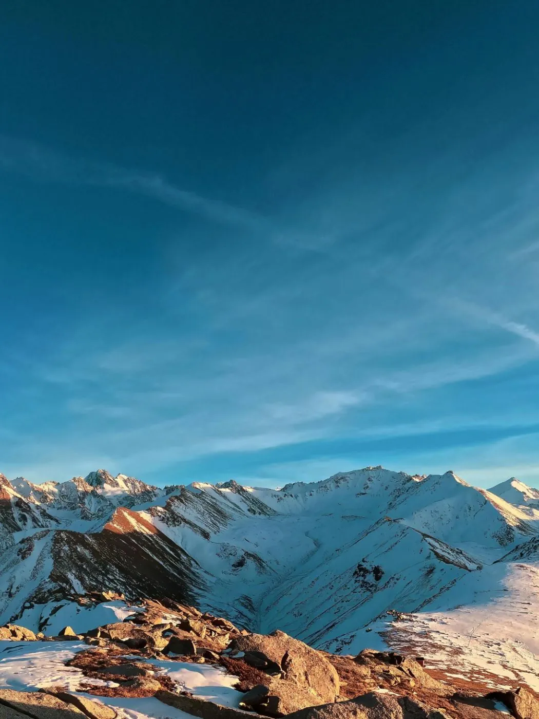 Snow-covered Rocky Mountain peaks under a clear blue winter sky